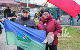 Bieg Niepodległości, zdjęcie uczestników wydarzenia, flaga Polski i flaga Ełku